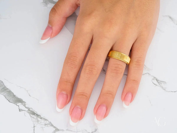 Womans hand with regal ridge art gold jewelry wedding band
