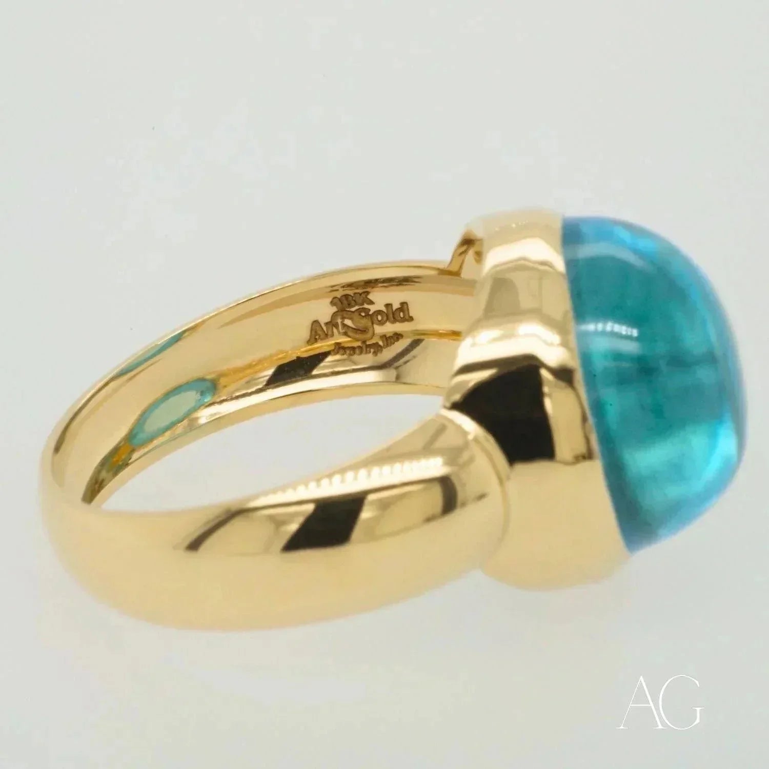 Elegant cabochon blue topaz ring with bezel-set blue-green gemstone