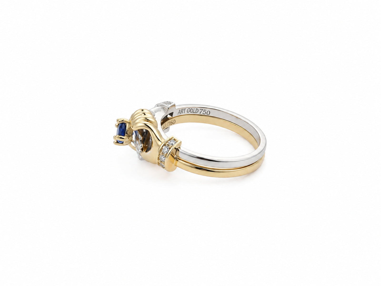Side profile of two-tone gold ring showing sculpted hand forms and sapphire setting