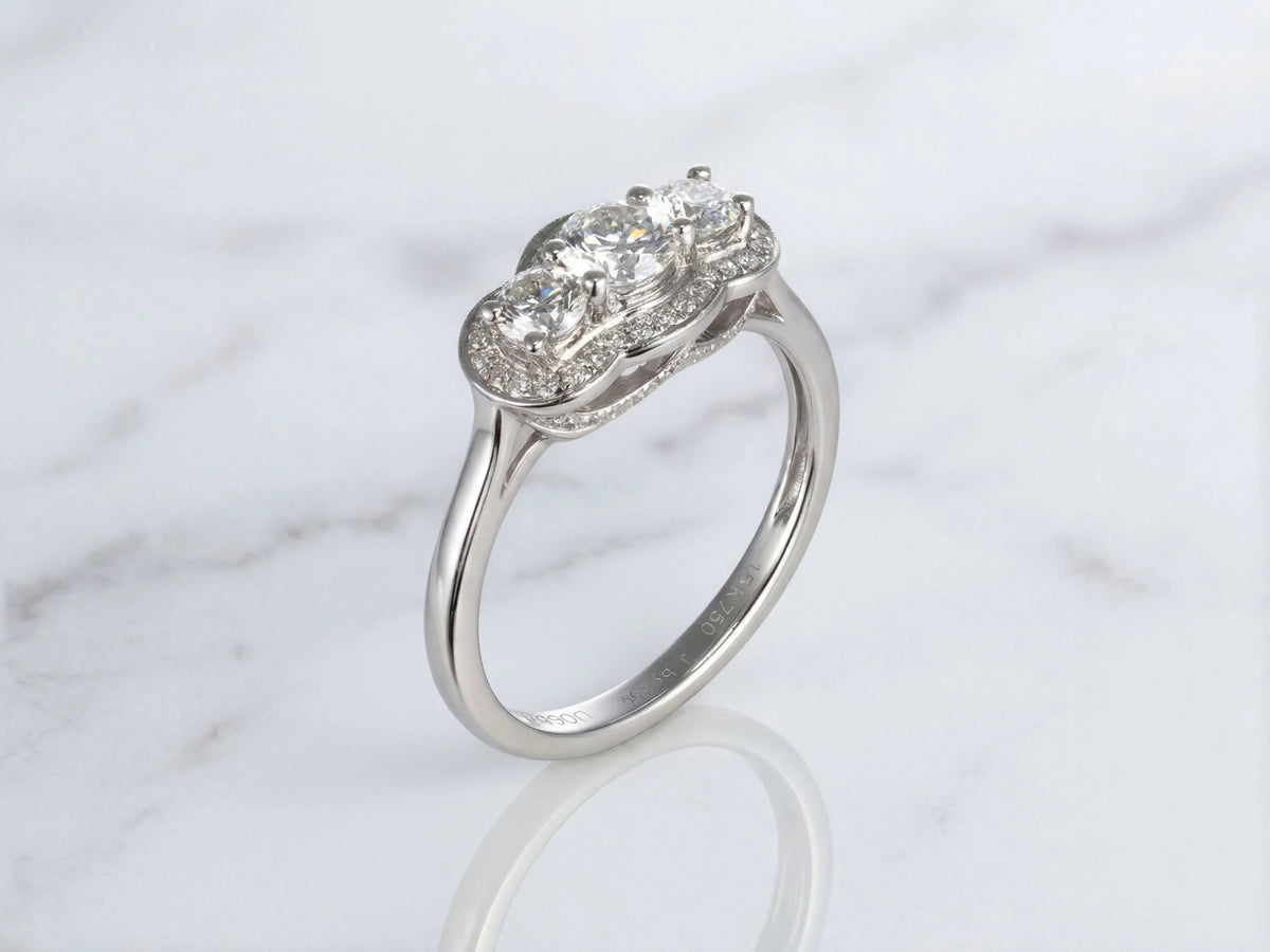 Side profile view of white gold three-stone diamond ring showing raised setting