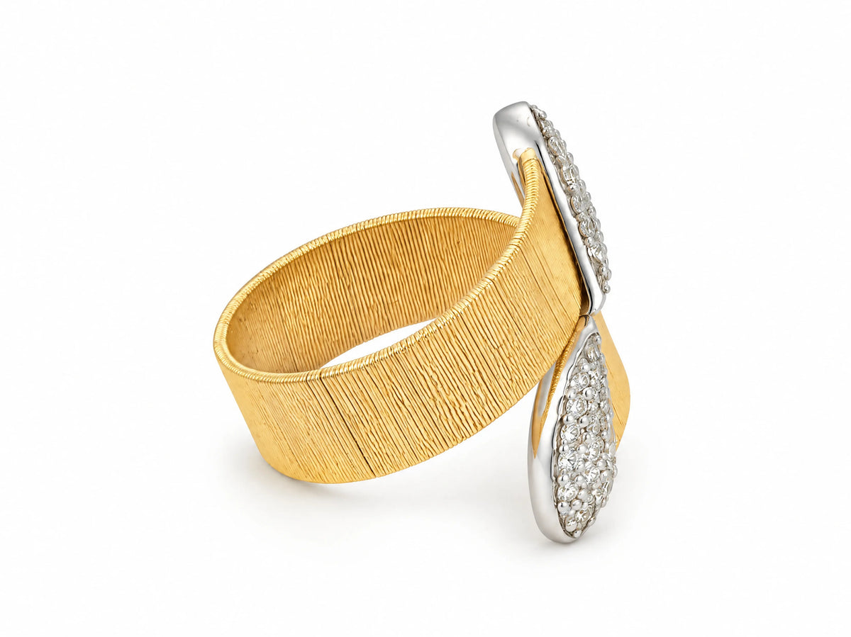 Alternate three-quarter view of the two-tone ring from the opposite side, showing the white gold ribbon crossing the band.