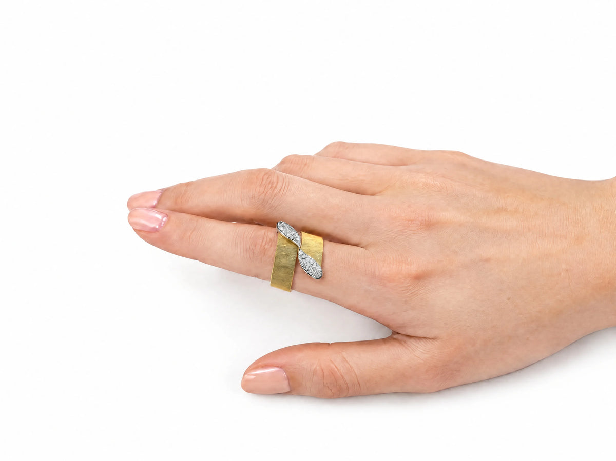 Hand-worn view of the two-tone ring on a ring finger, showing the brushed yellow gold band and the white gold pavé ribbon.