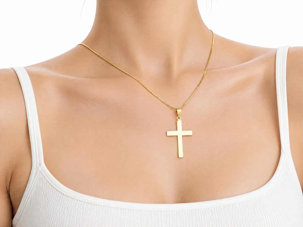 Smooth cross pendant M size worn for scale, 17 x 25 mm.