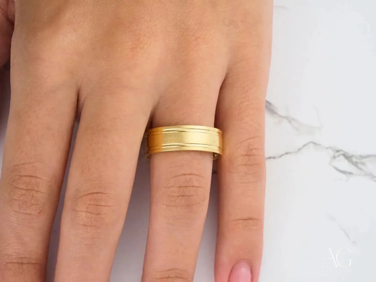 Two interlocking gold wedding bands on white fabric showcasing art gold jewelry and gold jewelry elegance.