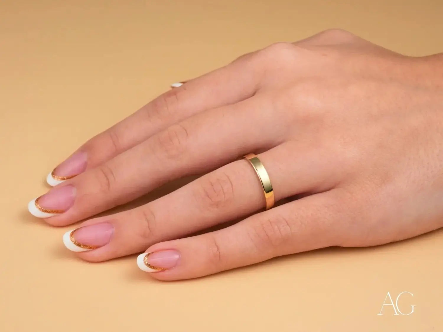 a sleek gold-colored 18k gold wedding band with a smooth polished finish worn on the ring finger featured in an article about crafting memories with handmade and heritage heirloom fine jewelry