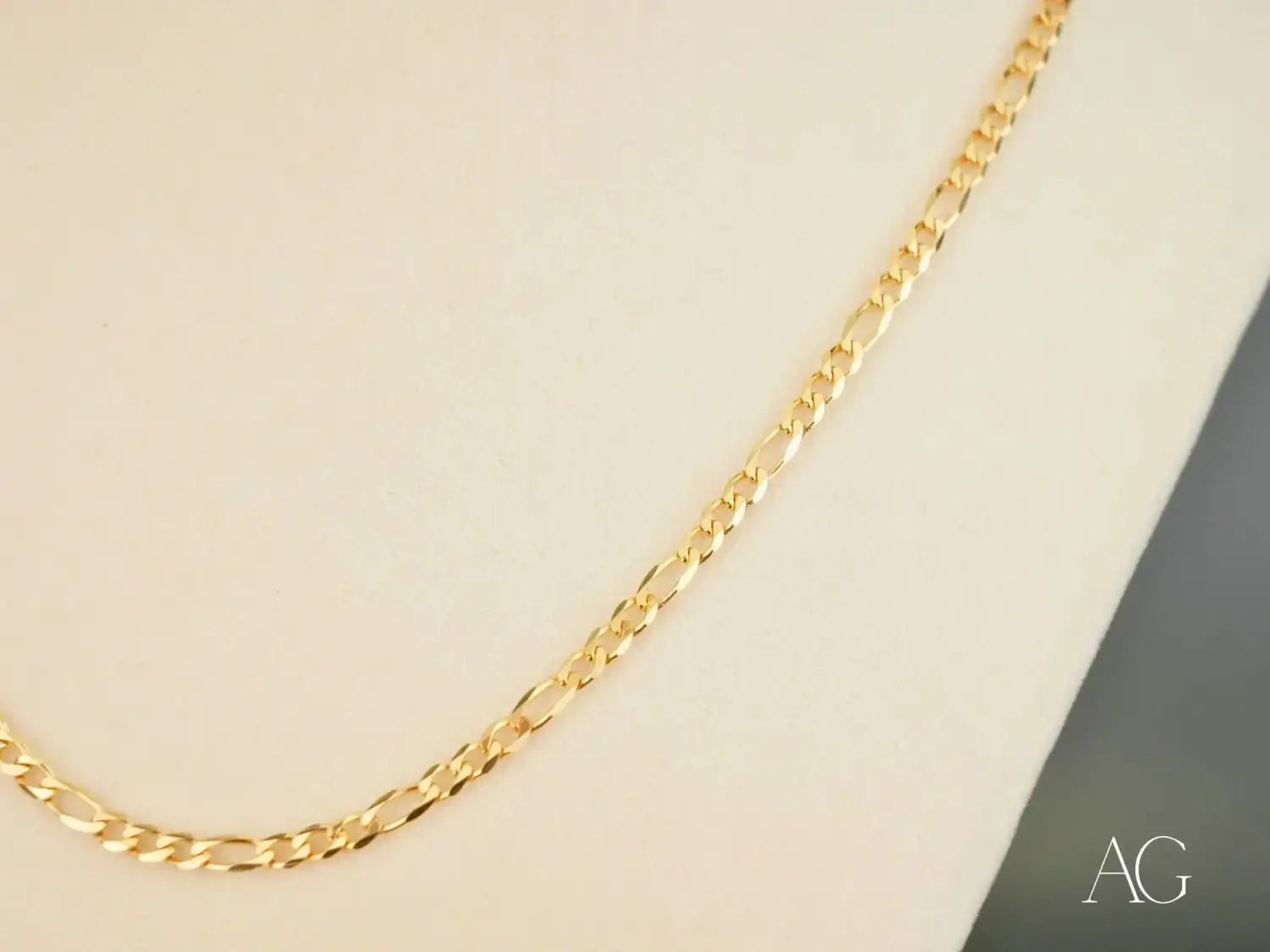 A sleek gold-toned figaro chain necklace with a polished metallic finish featured in an article on engagement rings and fine jewelry as symbols of secret meaning and modern traditions.