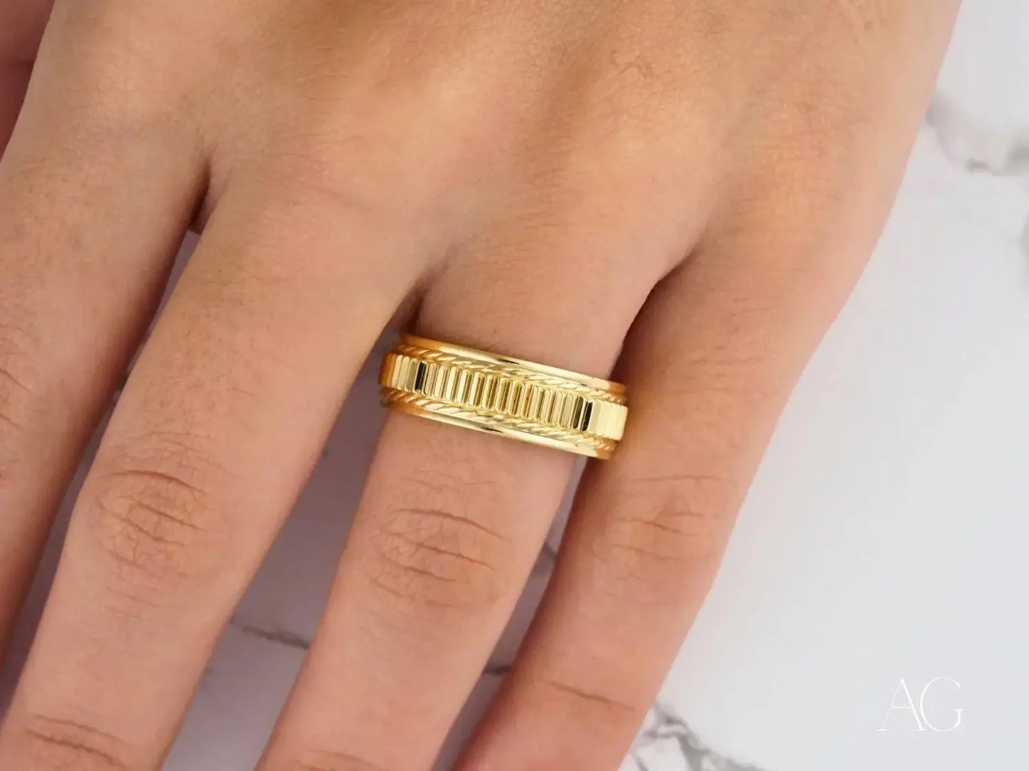 A woman’s hand wearing four unique diamond rings in silver-toned settings featured in a 18k gold jewelry care guide