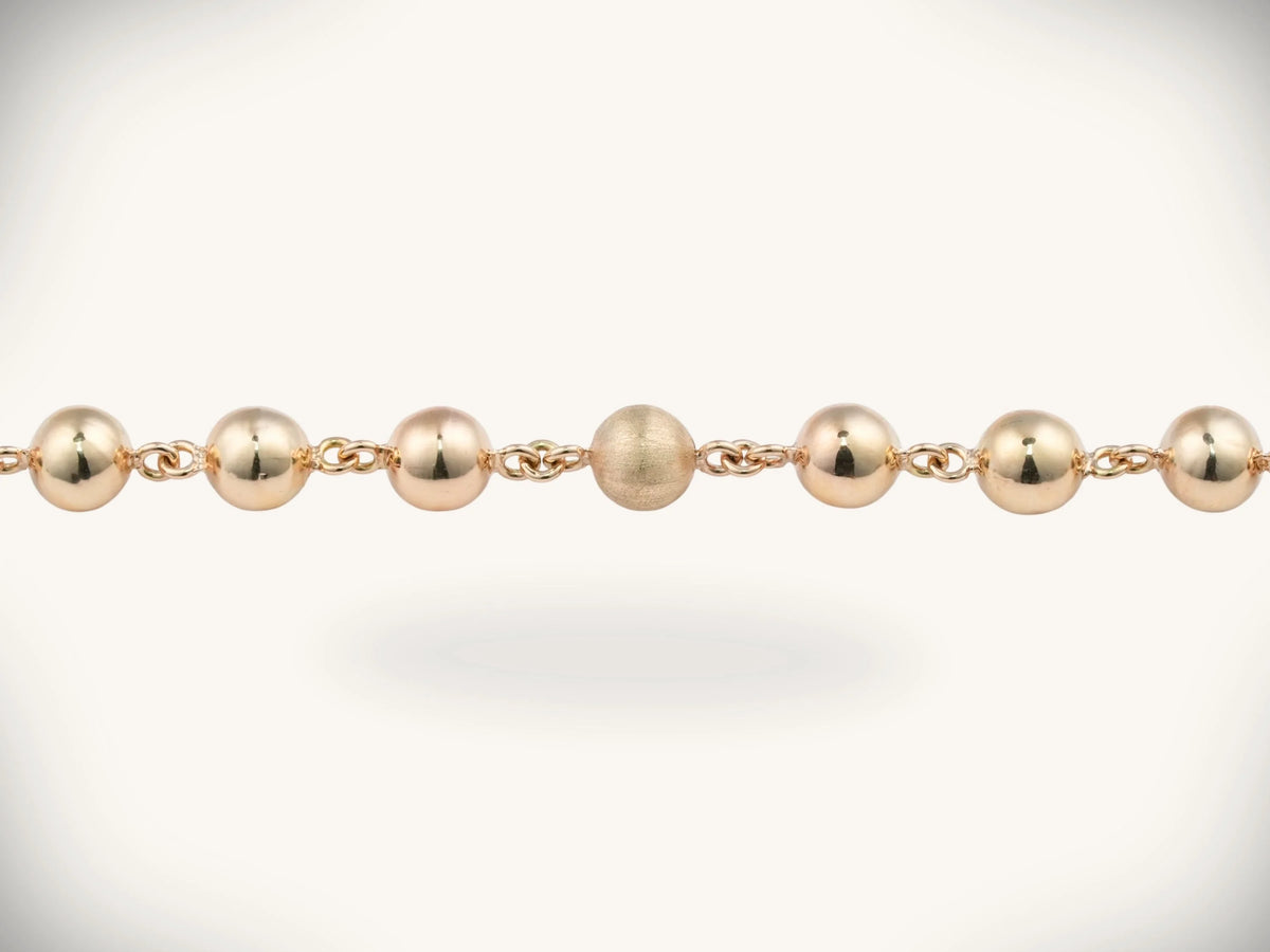Solid gold rosary necklace with gold-toned ball chain and emerald diamond cross