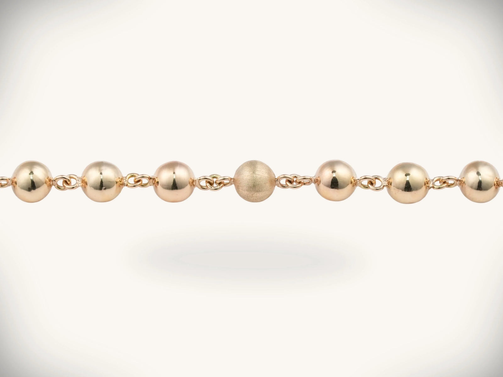 Solid gold rosary necklace with gold-toned ball chain and emerald diamond cross