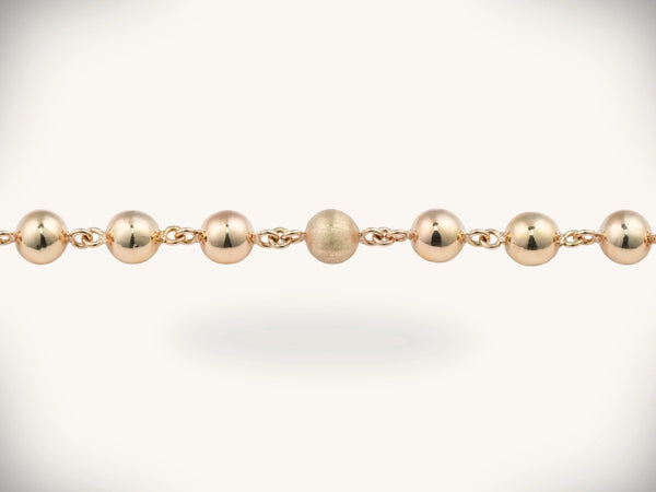 Solid gold rosary necklace with gold-toned ball chain and emerald diamond cross