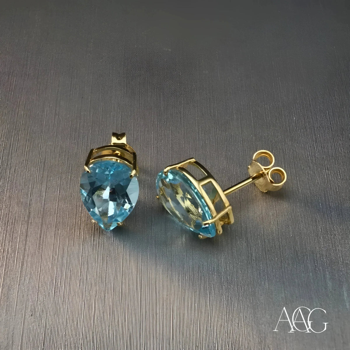 Sophisticated blue topaz gold earrings with pear-shaped gems