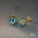 Sophisticated blue topaz gold earrings with pear-shaped gems