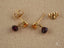 18k gold citrine and rubellite earrings featuring faceted orange gemstones and dark purple dangling stones