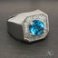 Silver men’s ring featuring a large Swiss Blue Topaz and baguette-cut diamonds