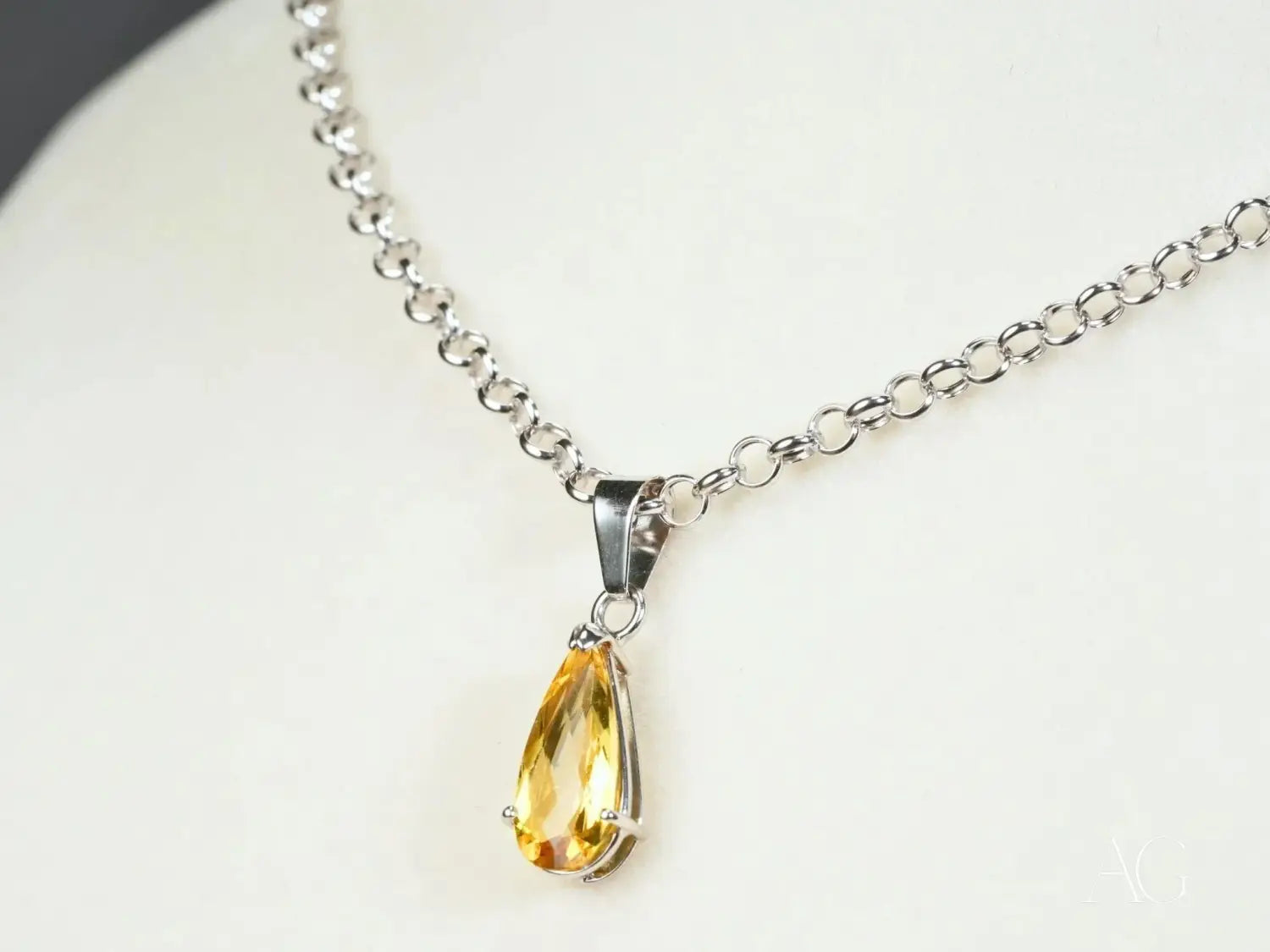 a teardrop-shaped yellow citrine pendant made of fine jewelry suspended from a delicate silver chain featured in a guide to famous jewelers highlighting their timeless impact on jewelry traditions including art gold and gold jewelry.