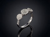 Three-stone diamond cluster ring, angled side view highlighting triple cluster design and diamond band
