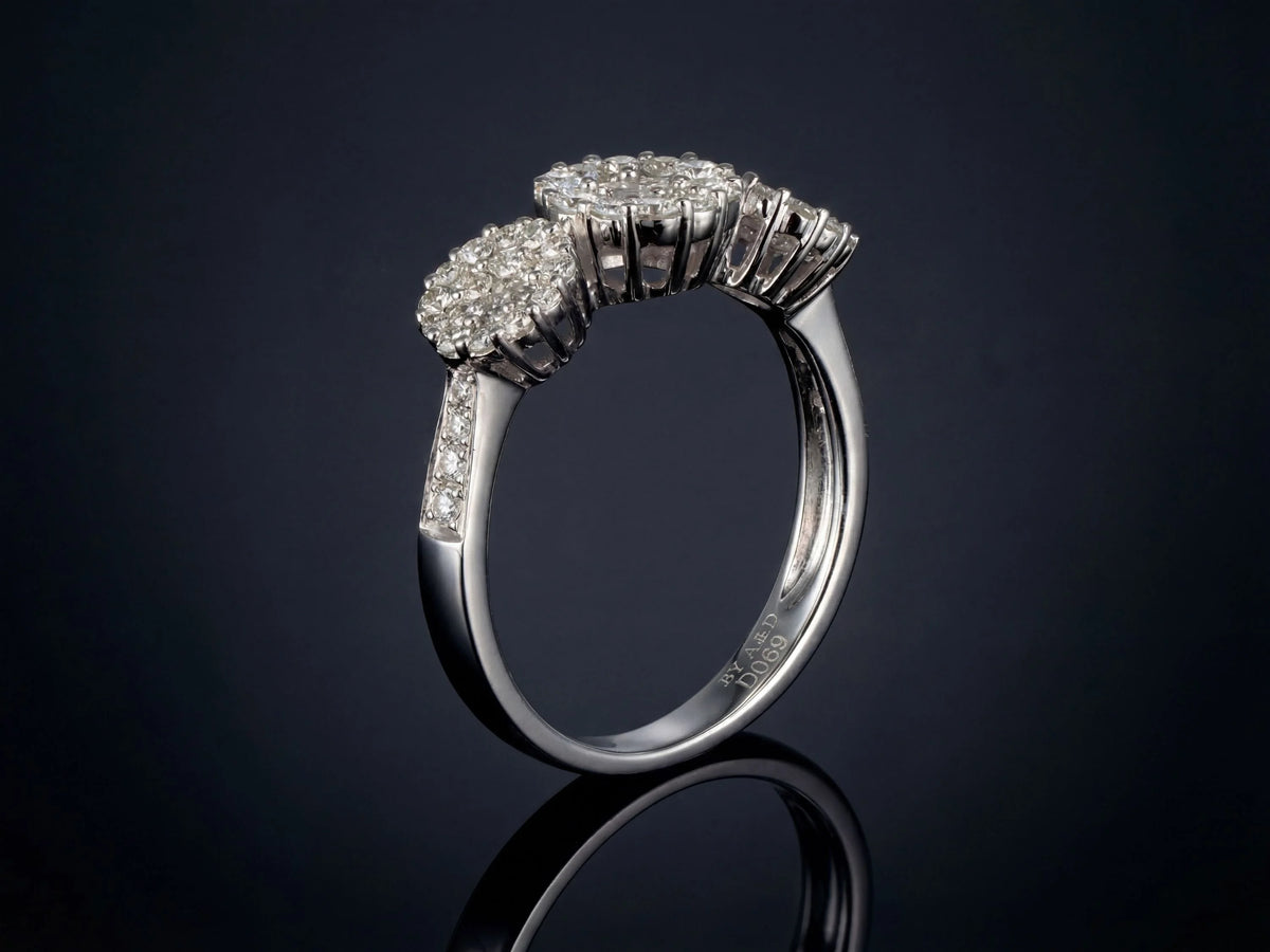 Three-stone diamond cluster ring, side profile showing raised cluster settings and diamond shoulders