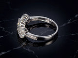 Three-stone diamond cluster ring, side view showing diamond shoulders and triple cluster setting