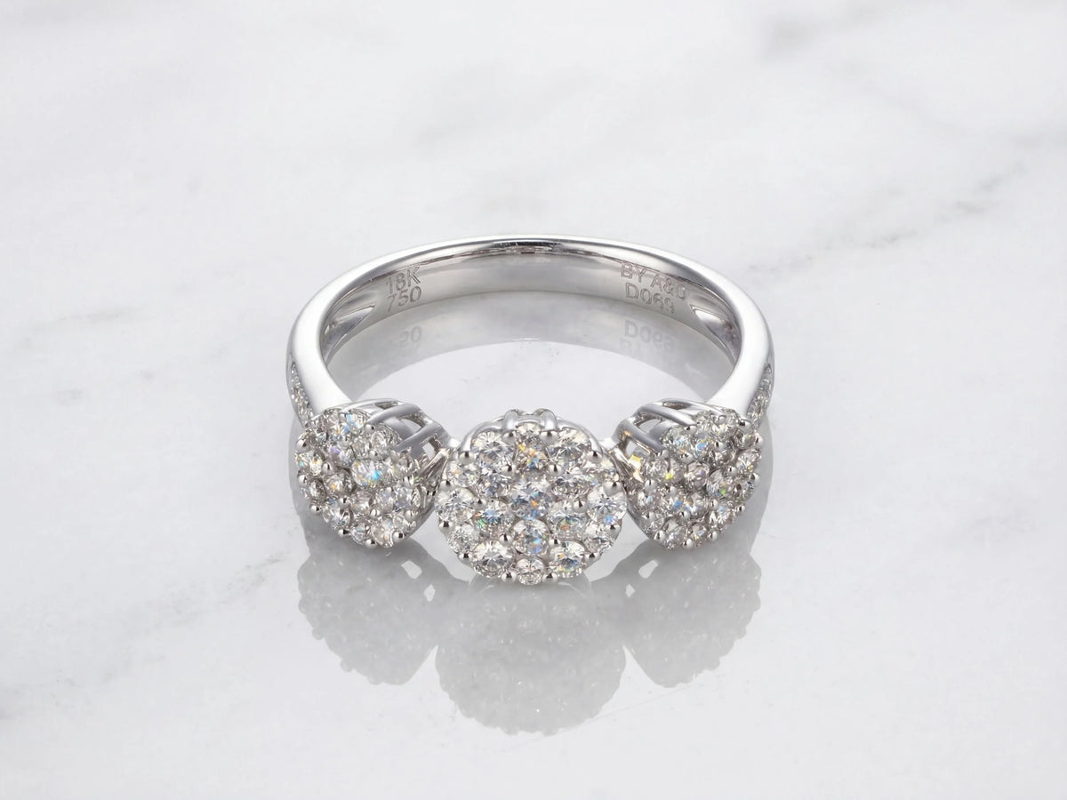 Three-stone diamond cluster ring, top-down view of three circular diamond clusters and diamond shoulders