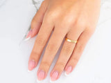 18k yellow gold wedding band on hand with French-tipped nails
