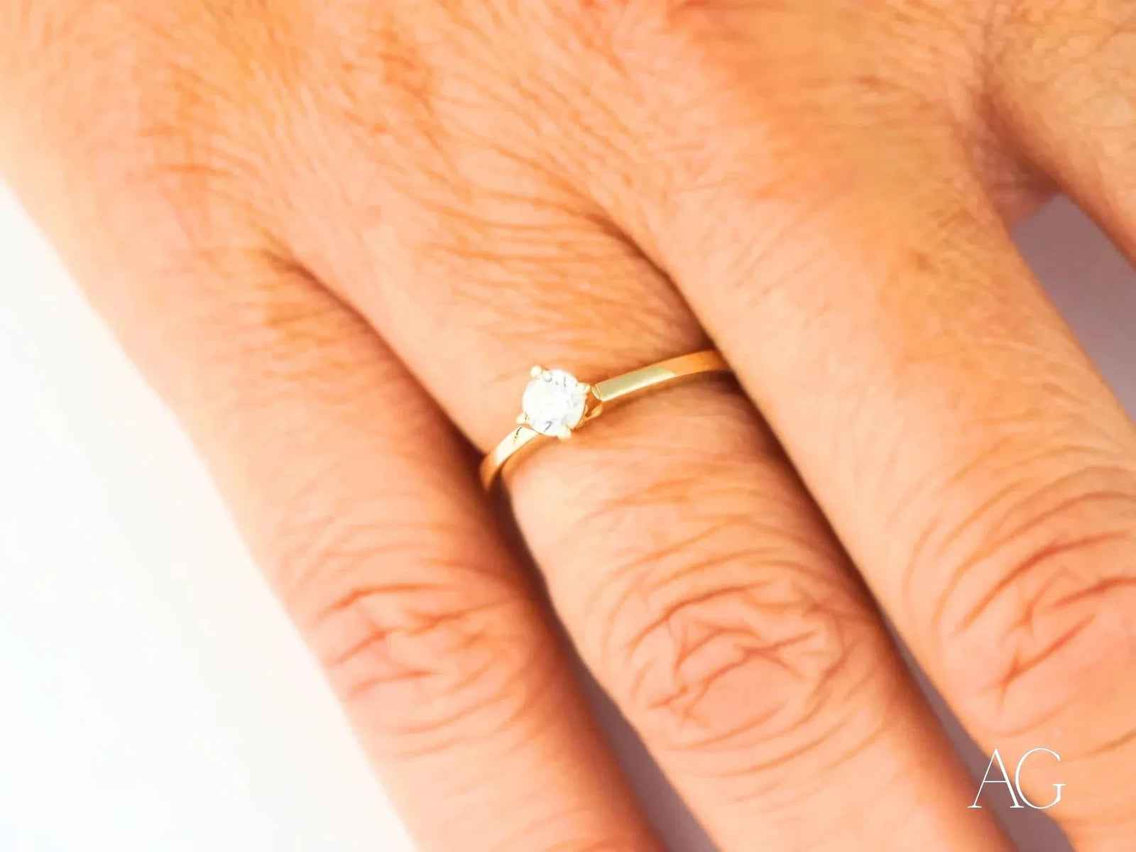 18k yellow gold solitaire ring with round cubic zirconia, side view showing prong setting