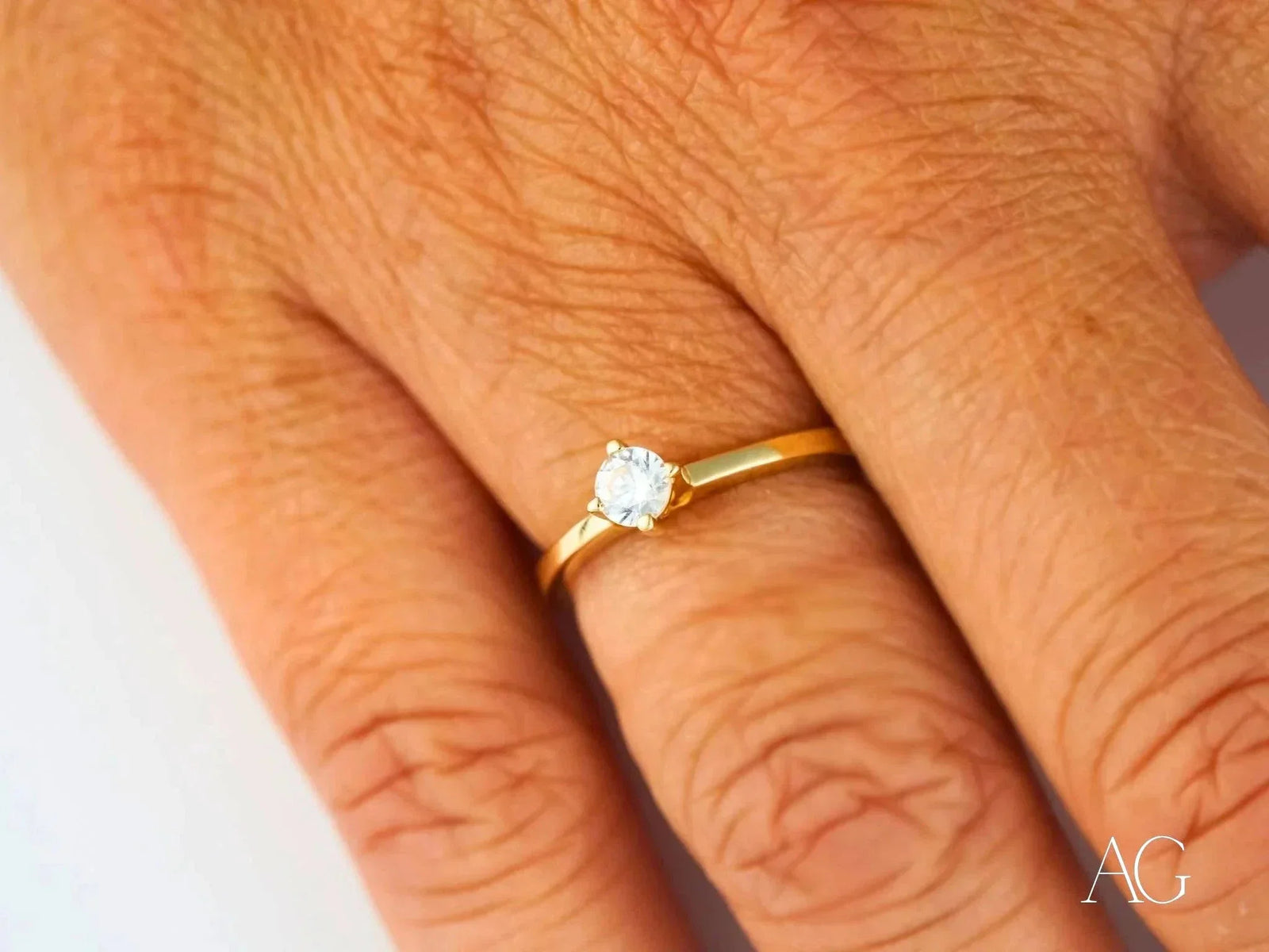 18k yellow gold solitaire ring with round cubic zirconia, three-quarter angle view