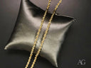 Two twisted solid 14k gold rope chains on black pillow with lobster lock