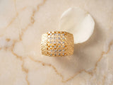 Top view of 18K gold wide band ring showing honeycomb lattice and white gold accents