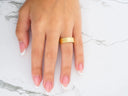 Womans hand with textured Twin Promise gold wedding band