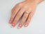 Hand wearing Twist of Brilliance Engagement Ring with twisted band and diamond focal point