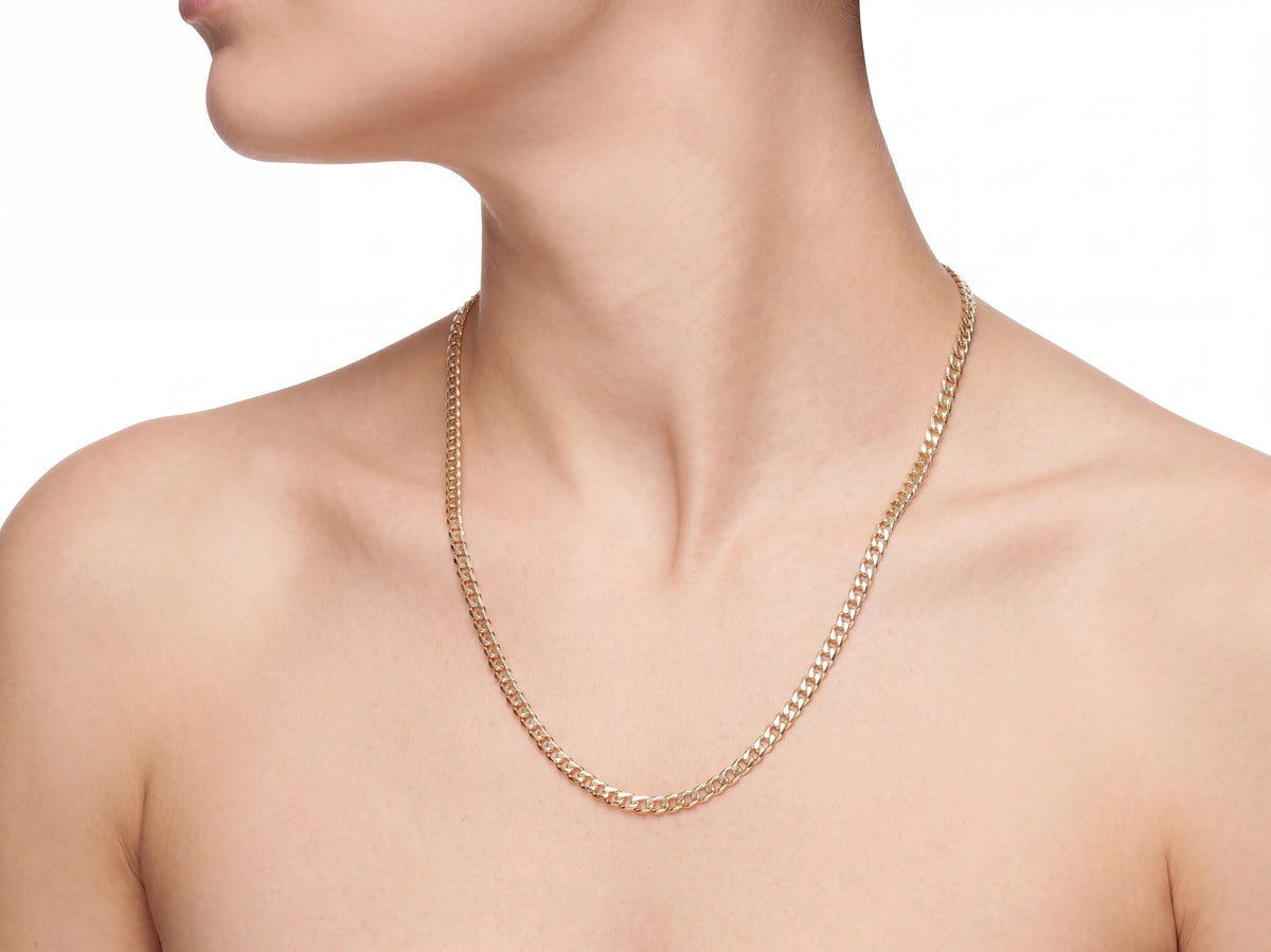 14K yellow gold Cuban chain worn on a model, the chain resting on the upper sternum