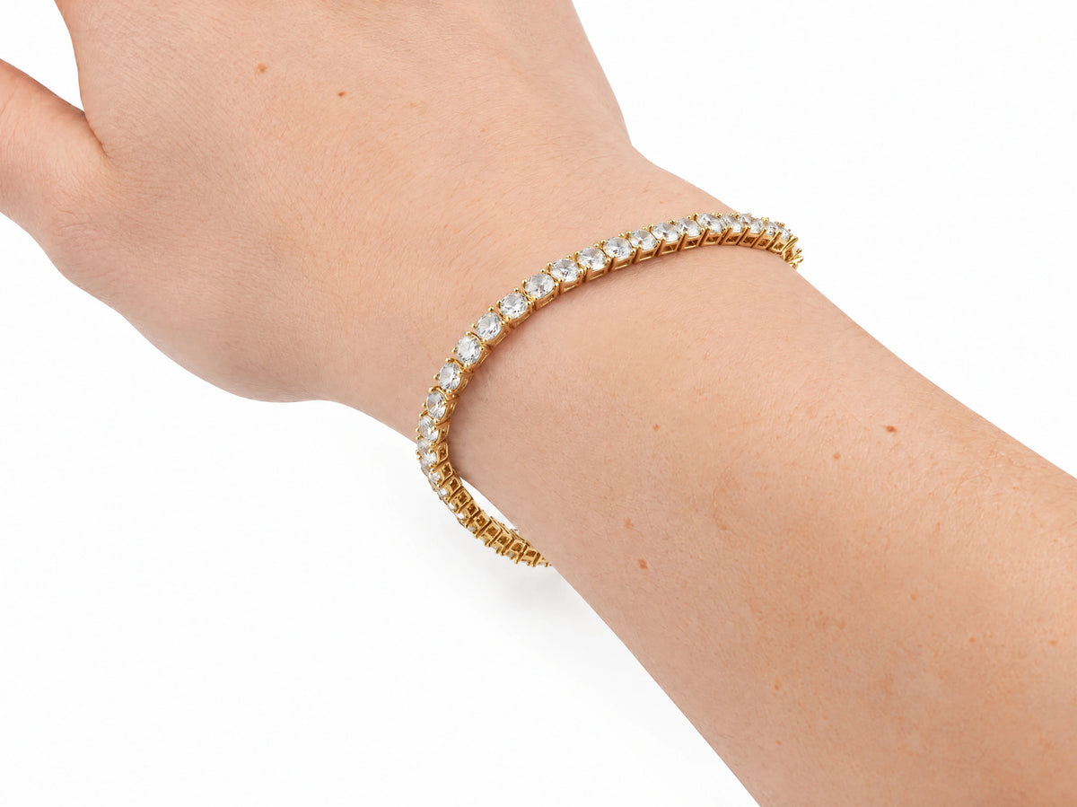 The zirconia tennis bracelet worn on a bare wrist, the row of round stones facing up across the top of the wrist