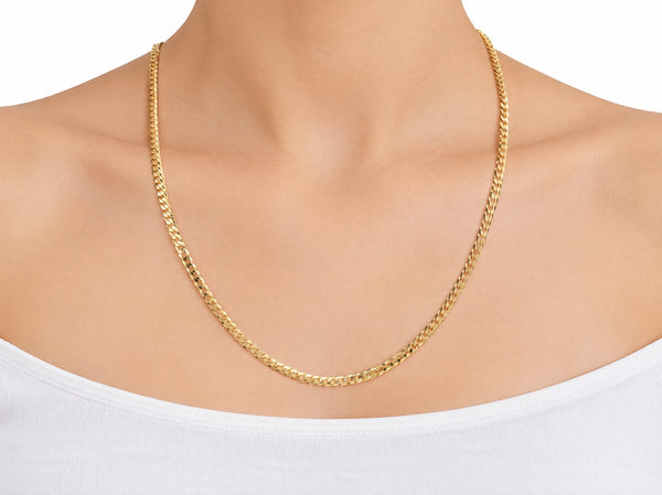 14K yellow gold Cuban chain worn on a model, crossing the collarbones to the upper chest