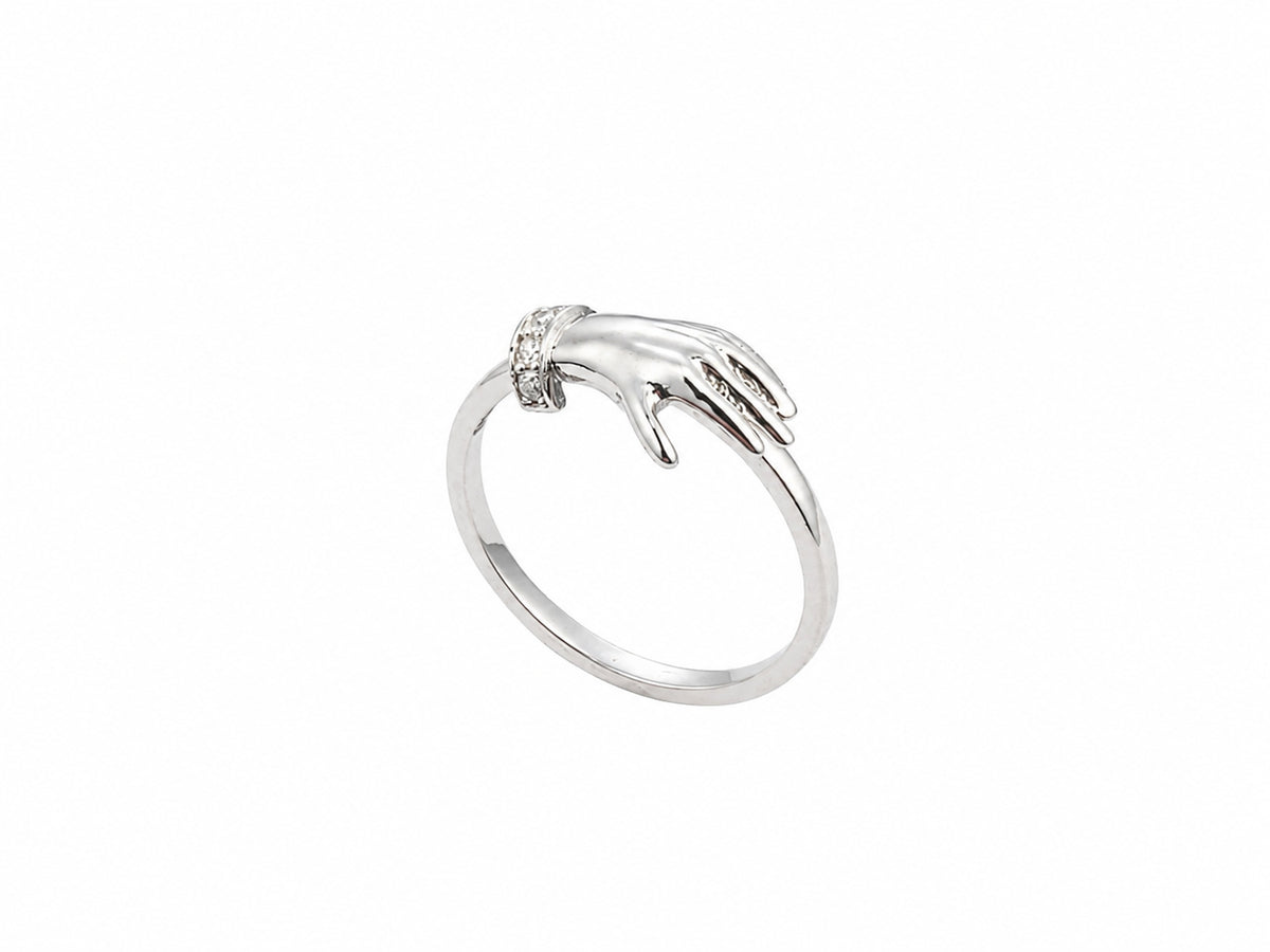 Side view of yellow gold ring with sculpted clasped hands, sapphire and diamond accents